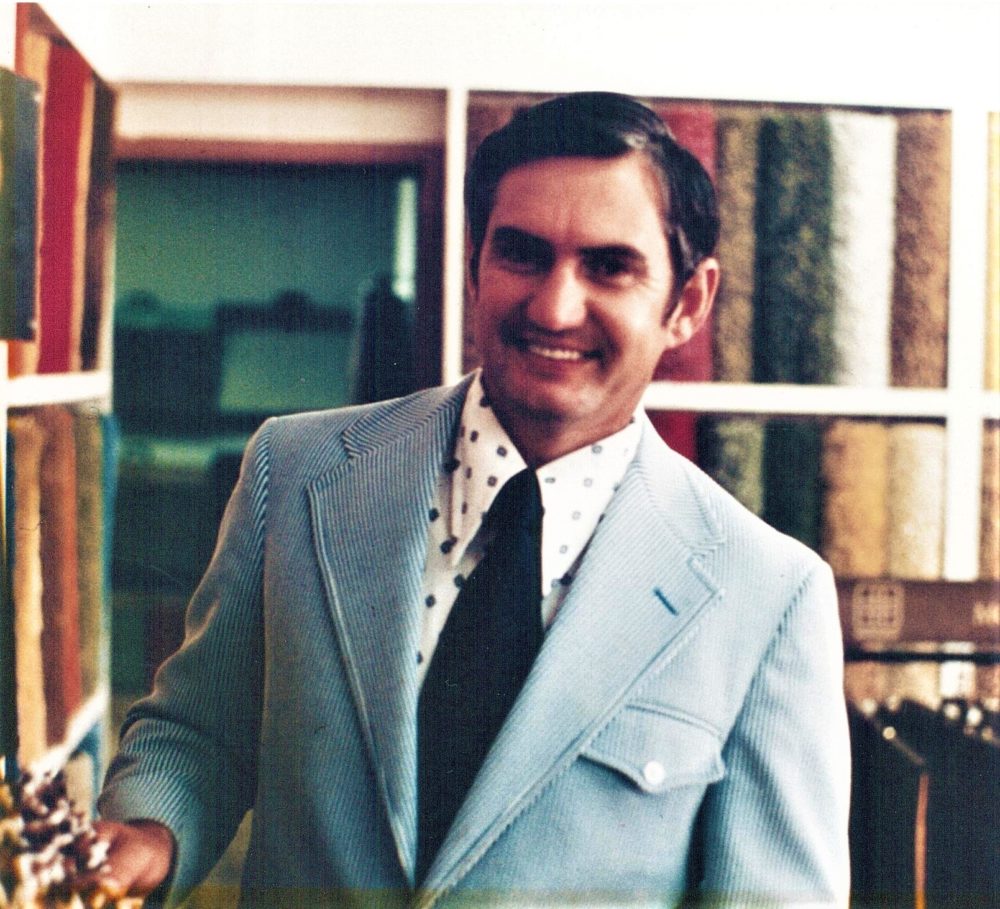 The Carpet Shoppe's owner, Dale, smiles in the showroom in the 1980s.